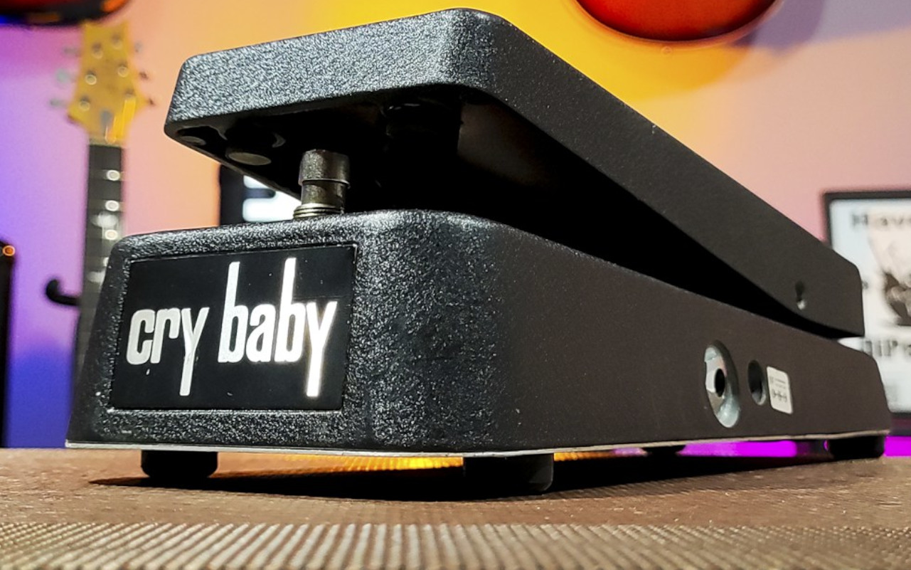 A imagem mosra um pedal dunlop cry baby em um cenário de estúdio