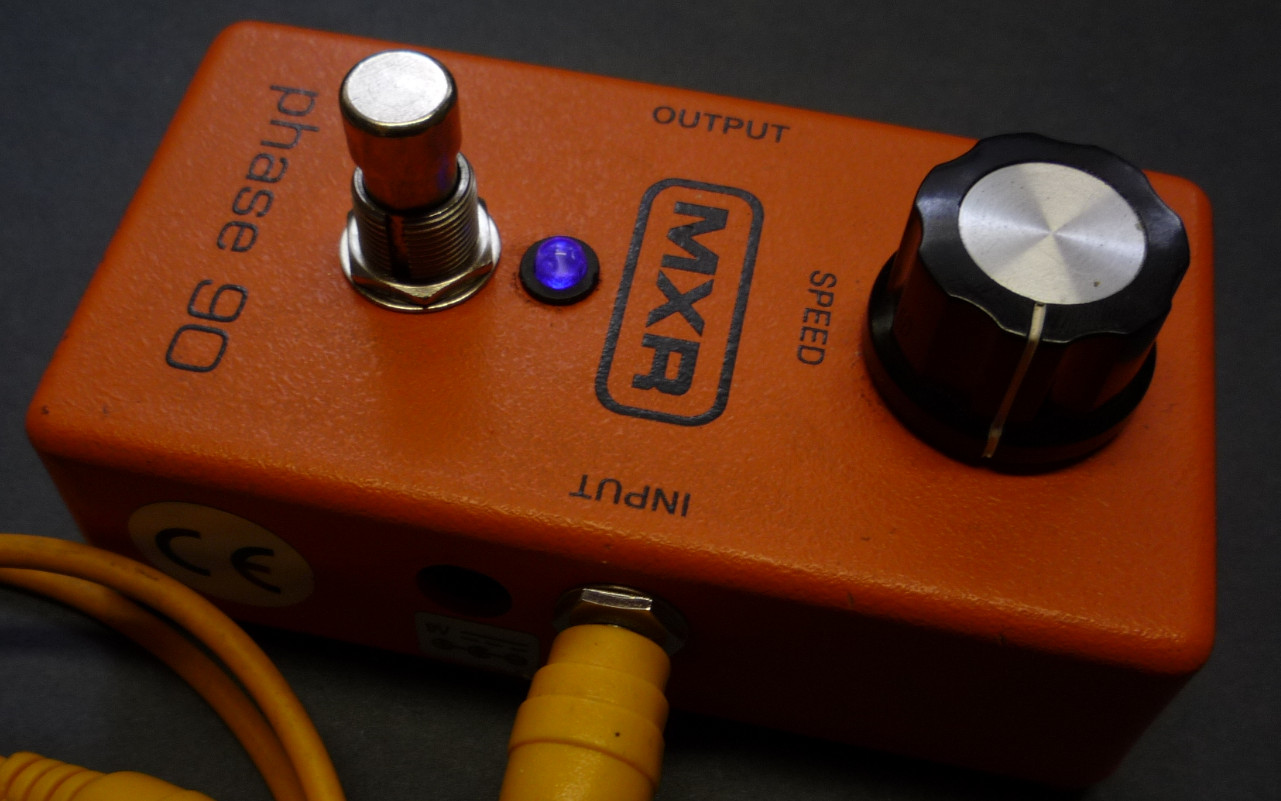 A imagem mostra um pedal de efeito MXR phase 90 de cor laranja.