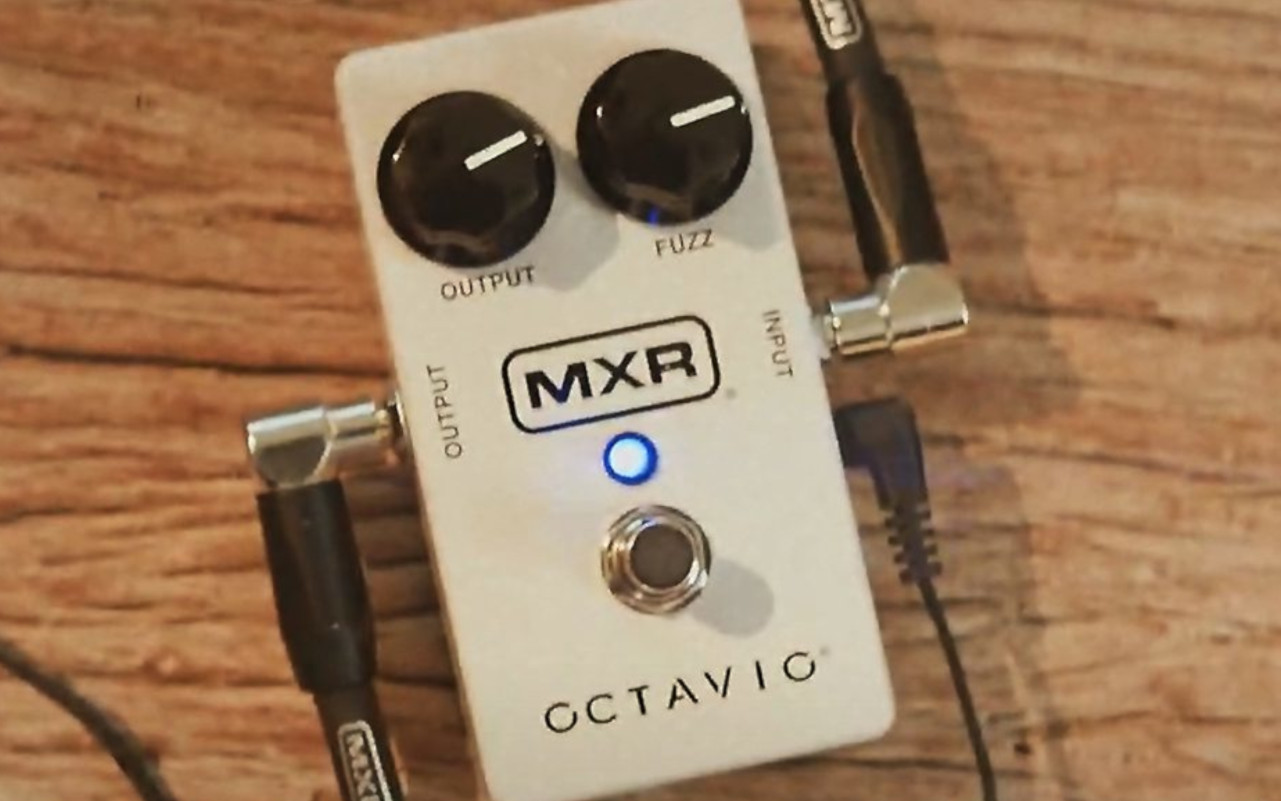 A imagem mostra um MXR M267 Octavio Fuzz em um fundo de madeira