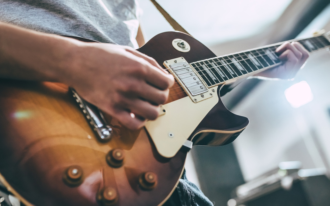 A imagem mostra um guitarrista tocando a escala pentatônica menor